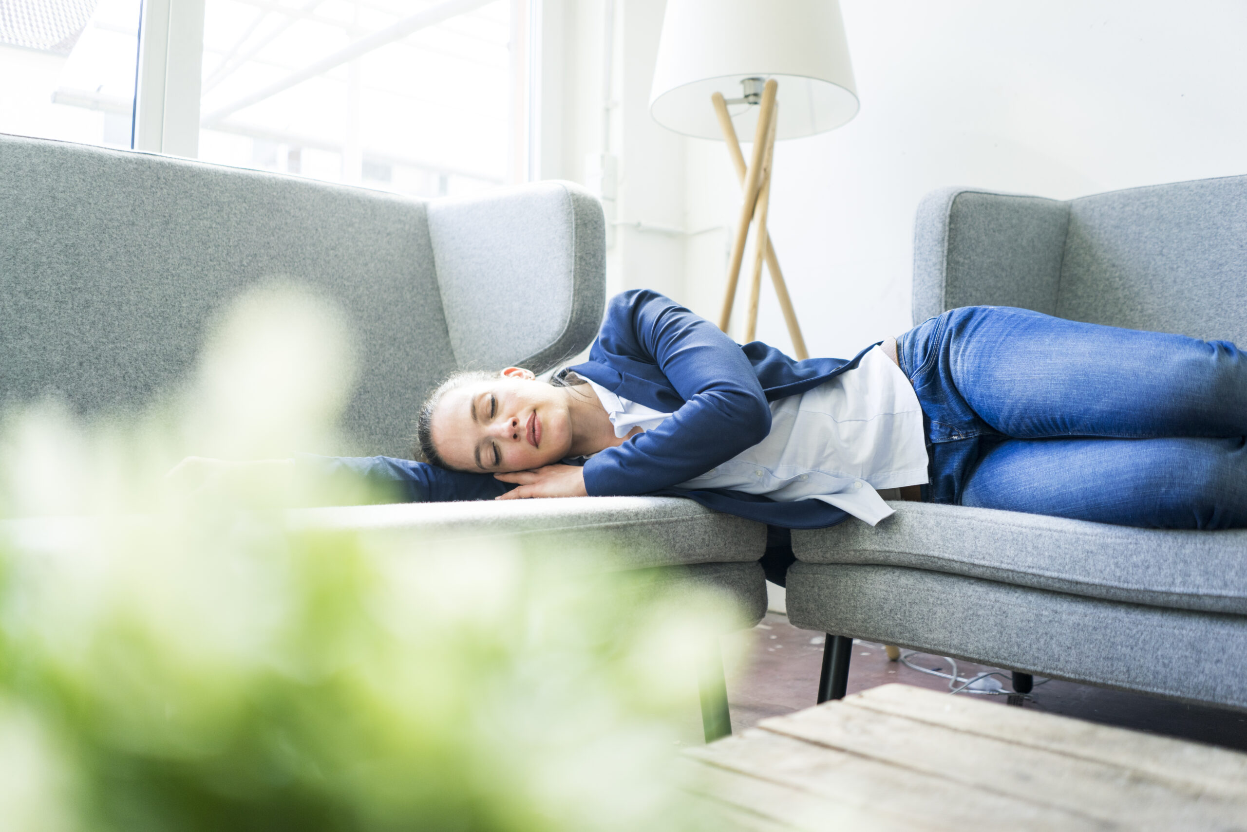 Businesswoman lying on couch sleeping